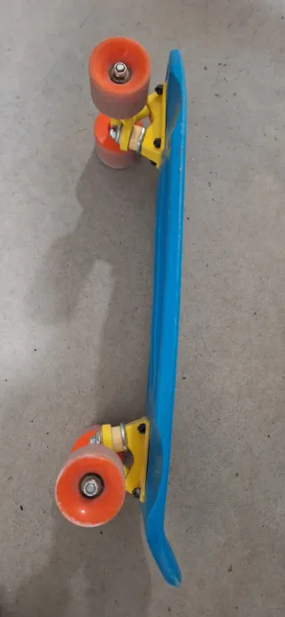 Patineta azul con ruedas naranjas