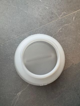 Bote blanco con tapa negra de plástico.