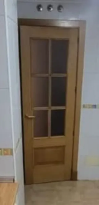 Puerta de madera con cristal. Quiñón Seseña