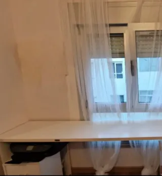 Escritorio blanco con baúl de almacenaje.