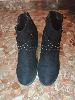 Botas negras con tachuelas y hebilla.