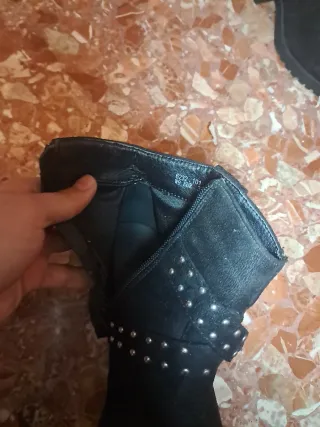 Botas negras con tachuelas y hebilla.