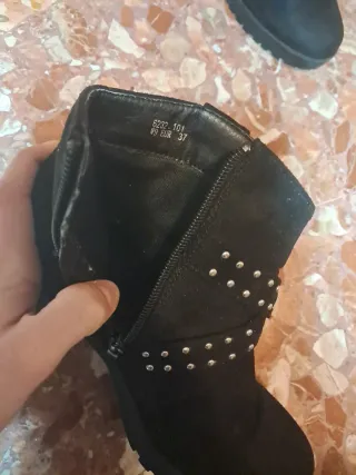 Botas negras con tachuelas y hebilla.