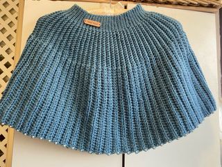 Capa tejida azul con perlas