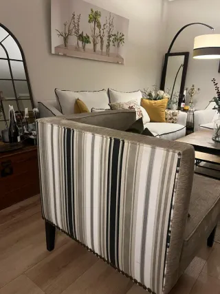 Butaca esquinera tapizada con tachuelas