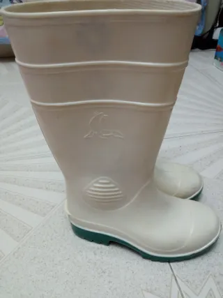 Botas de agua blancas con suela verde.