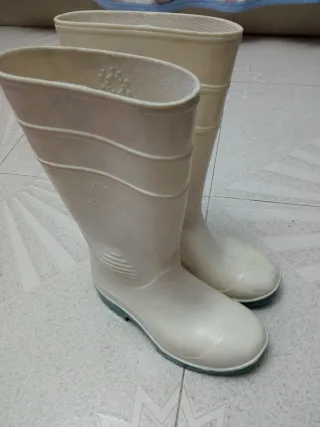 Botas de agua blancas con suela verde.
