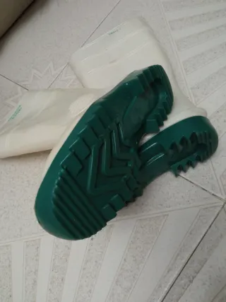 Botas de agua blancas con suela verde.