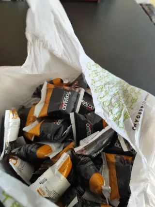 Macchina da caffè rossa con sacchetto di capsule