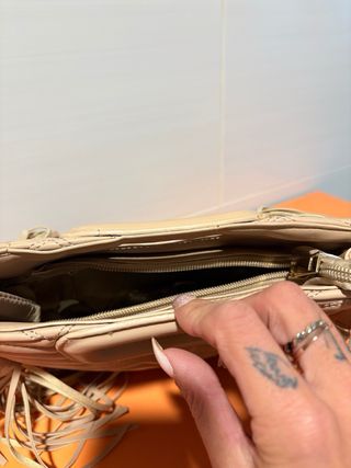 Bolso beige con diseño acolchado y flecos