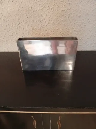 Jarrón metálico plateado.