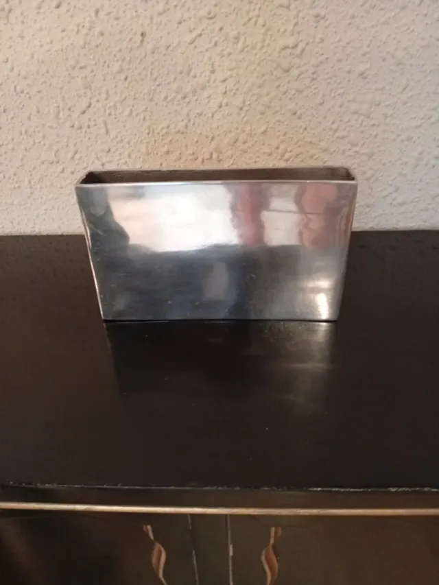 Jarrón metálico plateado.