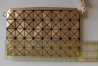 Bolso de mano dorado geométrico