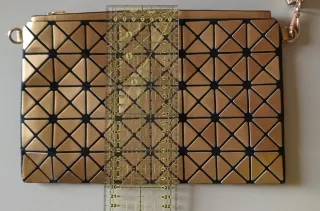 Bolso de mano dorado geométrico