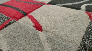 Alfombra cuadros rojos, grises, blancos y negros