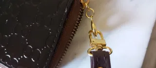 Cartera de mano marrón con detalles dorados