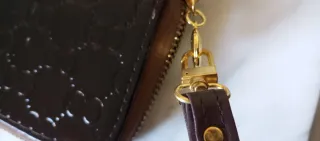 Cartera de mano marrón con detalles dorados