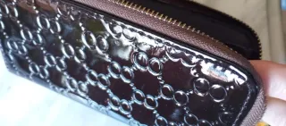 Cartera de mano marrón con detalles dorados
