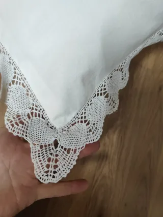 Cojín blanco con bordado floral y encaje bolillo