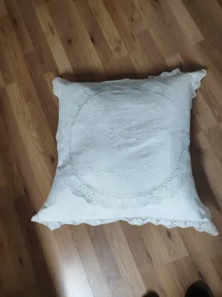 Cojín blanco con bordado floral y encaje bolillo