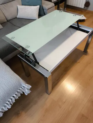 Mesa de centro elevable de cristal y metal.