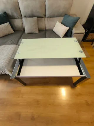 Mesa de centro elevable de cristal y metal.