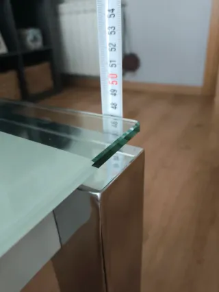 Mesa de centro elevable de cristal y metal.