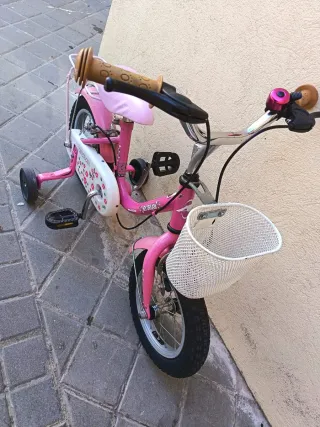 Bicicleta infantil rosa con ruedines