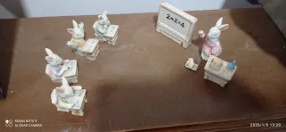 Figuras conejos sentados en pupitre