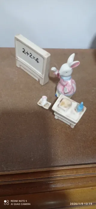 Figuras conejos sentados en pupitre