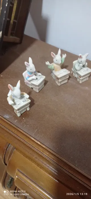 Figuras conejos sentados en pupitre