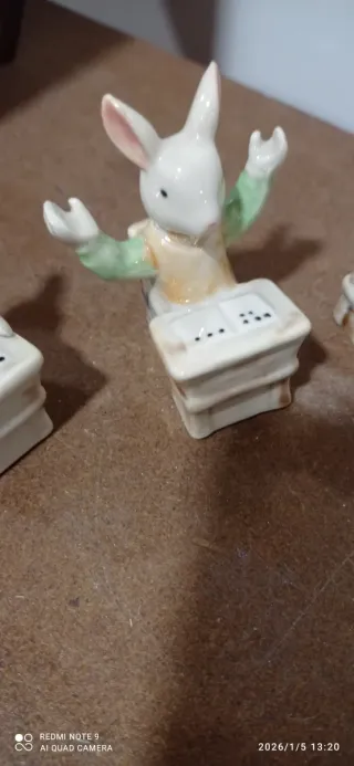 Figuras conejos sentados en pupitre