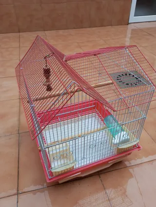 Jaula para pájaros roja y blanca.