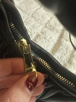 Bolso Miu Miu negro con detalles dorados