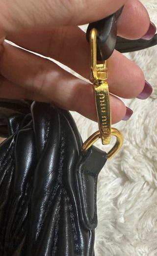 Bolso Miu Miu negro con detalles dorados