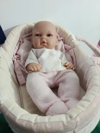 Muñeca bebé en cunita rosa