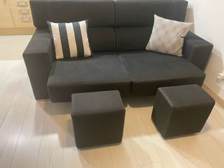 Sofá negro con 2 puffs