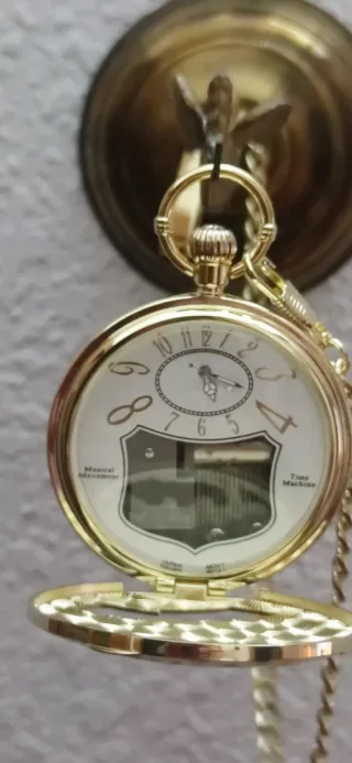Reloj de bolsillo musical dorado