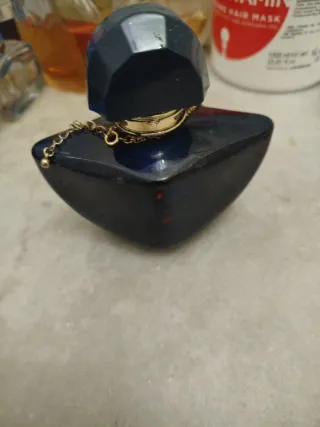 Perfume azul con cadena dorada