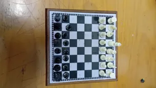 Mini ajedrez en mueble pequeño de madera.