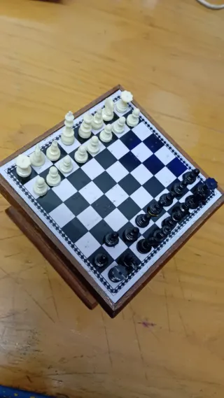 Mini ajedrez en mueble pequeño de madera.