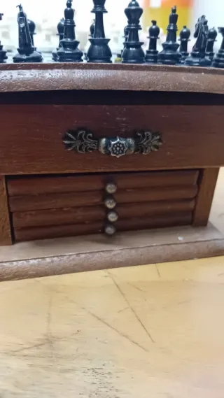 Mini ajedrez en mueble pequeño de madera.