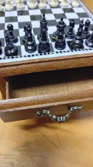 Mini ajedrez en mueble pequeño de madera.