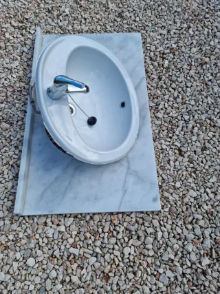 Lavabo de cerámica con grifo y encimera de mármol