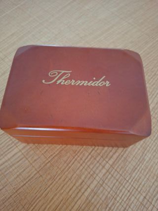 Reloj Thermidor Dorado con correa de cuero rojo.