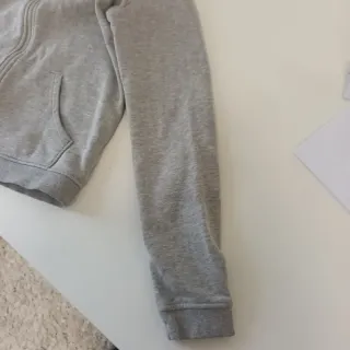 Sudadera gris con capucha y cremallera