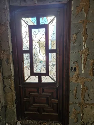 Puerta madera con reja y cristal