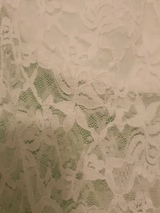 Top de encaje blanco con hombros descubiertos.