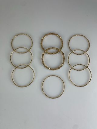 Serie 9 braccialetti dorati con inserti luminosi