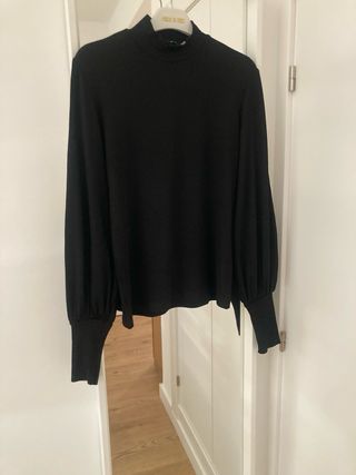 Jersey negro cuello alto manga abullonada